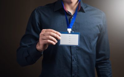 man holding id tag on brown background